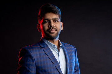 Indian young businessman on dark background