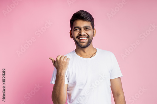 Fotografía Portrait of handsome Indian guy standing on pink background