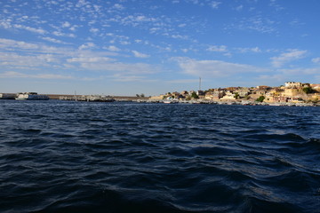 River Nile/ beautiful view for Aswan Egypt and Nubian Egyptian culture. sailing boat sailing in the River Nile and harbor with birds and local houses on the 2 sides 