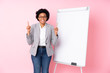 African american business woman giving a presentation on white board over isolated pink background pointing up a great idea