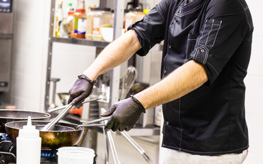 Chef in the kitchen at the restaurant prepares dishes