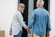 © LIGHTFIELD STUDIOS - smiling mature woman and man holding hands near new house
