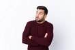 © luismolinero - Young handsome man with beard over isolated white background making doubts gesture while lifting the shoulders
