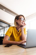 © Drobot Dean - Photo of joyful young woman using laptop and smiling while sitting