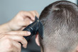© donikz - Barber haircut, hair of a young man with a hair clipper. Hair styling concept.