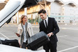 © Drobot Dean - Image of young businesslike man and woman putting luggage in car trunk