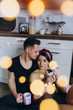 © dimadasha - Beautiful photo session of a couple in love. A guy and a girl in the kitchen are drinking tea.