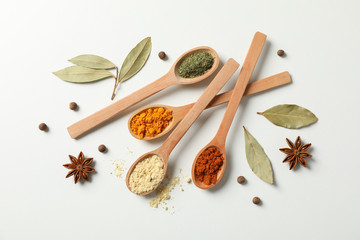 Sticker - Spoons with different spices and ingredients on white background, top view