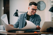 © JustLife - Young businessman working on project. Handsome architect in office.