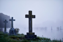Crosses On Gravestones In Ethereal Flooded Foggy Cemetery