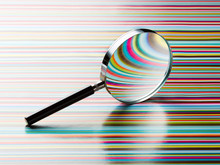 Magnifying Glass Leaning On Striped Background