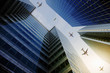 © Anthony Lee/Caia Image - Airplanes flying in a row over highrise buildings, travel concept