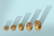 © Adam Gault/Caia Image - Ascending stacks of pound coins with bar graph growth shadow