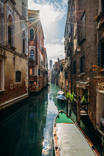 Sun Shining Over Tranquil Buildings Canal With Gondolas, Venice, Italy
