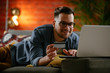 © JustLife - Young man paying online. Using e-banking