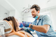 © Тарас Нагирняк - Dentist male examining patient teeth with a mouth dental excavator. Close-up view on the woman's face