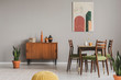 © Photographee.eu - Vintage grey dining room with abstract paintings and wooden cupboard