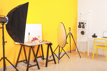 Interior of modern photo studio with professional equipment and food on table