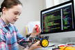 Leinwandbild Motiv Female Pupil Building Robot Car In School Science Lesson