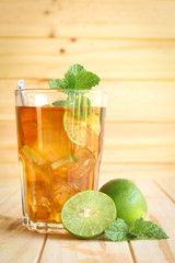 Wall Mural - ice tea with slice of lemon in glass on the wooden background