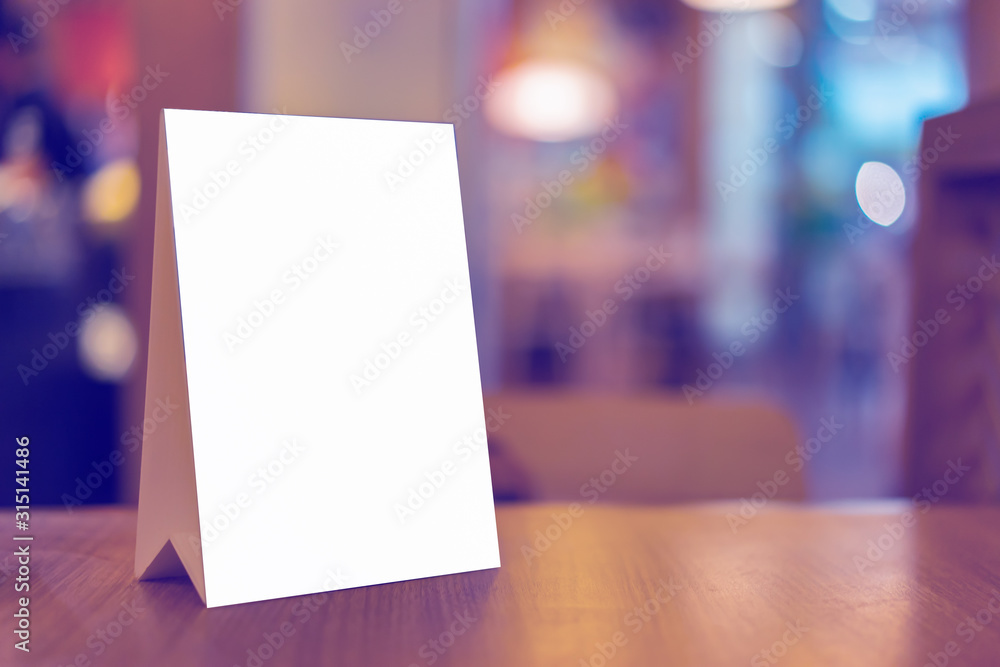 Mock up Label the blank menu frame in Bar restaurant ,Stand for booklets with white sheets paper acrylic tent card on wooden table cafeteria blurred background can inserting the text of the customer. - obrazy, fototapety, plakaty 