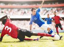 Soccer Players Kicking Ball On Field