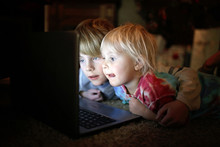 Two Little Children Watching Internet Video On Their Laptop Computer