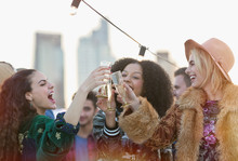 Enthusiastic Young Women Toasting Champagne Glasses At Rooftop Party