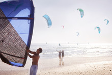 Man Preparing Kiteboarding Kite On Sunny Beach