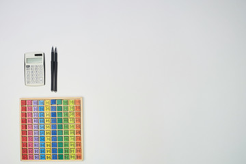 Multiplication table .Macro mode. Colored wooden cubes. Teaching children math and numeracy. Mental math. Calculator and pens, copy space