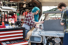 Mechanics Fixing Car Engine In Auto Repair Shop