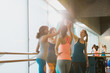 © Justin Pumfrey/Caia Image - Women high fiving in sunny gym studio