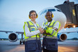 © Chris Ryan/Caia Image - Portrait confident air traffic control ground crew workers near airplane on airport tarmac