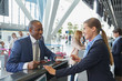 © Chris Ryan/Caia Image - Customer service representative helping businessman at airport check-in counter