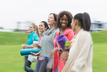 Smiling Women Friends Walking With Yoga Mats And Coffee