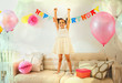 © Robert Daly/Caia Image - Portrait confident girl with arms raised on sofa at birthday party