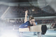 © Chris Ryan/Caia Image - Female gymnast practicing on balance beam in arena