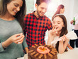 © Robert Daly/Caia Image - Family icing and decorating chocolate cake