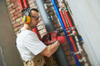 © Kadmy - plumber drilling a hole in wall before water equipment installation