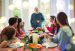© Robert Daly/Caia Image - Grandfather preparing to carve Christmas turkey at dinner table