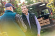© Agnieszka Olek/Caia Image - Smiling male farmer and customer handshaking in apple orchard
