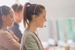 © Tom Merton/Caia Image - Smiling female telemarketer wearing headset talking on telephone in office