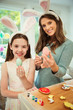 © Robert Daly/Caia Image - Portrait smiling mother daughter wearing costume rabbit ears showing decorated Easter eggs