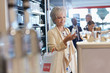 © Chris Ryan/Caia Image - Smiling woman shopping for perfume in duty free shop