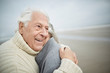 © Great Images/Caia Image - Affectionate senior couple hugging on winter beach