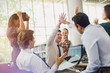 © Tom Merton/Caia Image - Business people high-fiving and celebrating in office