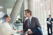 © Tom Merton/Caia Image - Businessman and businesswoman handshaking in sunny office lobby