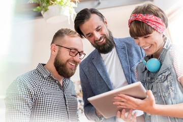 Smiling design professionals using digital tablet
