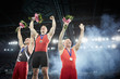 © Chris Ryan/Caia Image - Male gymnasts celebrating victory cheering on winners podium