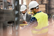 © Agnieszka Olek/Caia Image - Manager with clipboard and steel worker with tape measure in factory